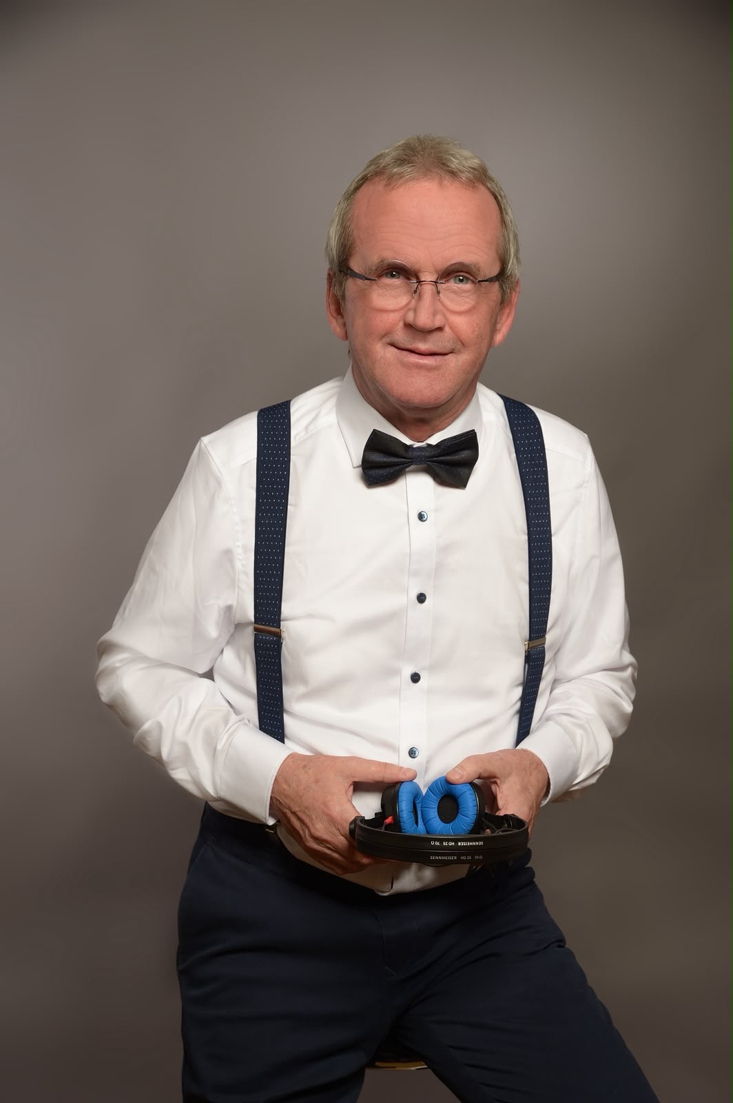 Christian mit Fliege und Kopfhörer in der Hand