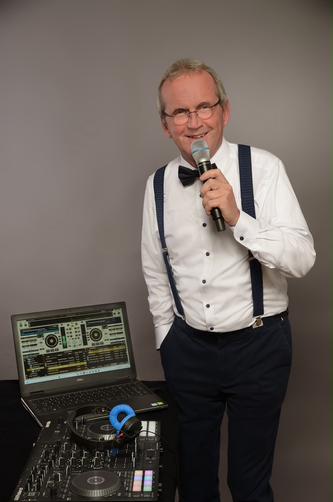 Christian, DJ Perfekt Event, mit Fliege und Mikrofon am DJ-Pult