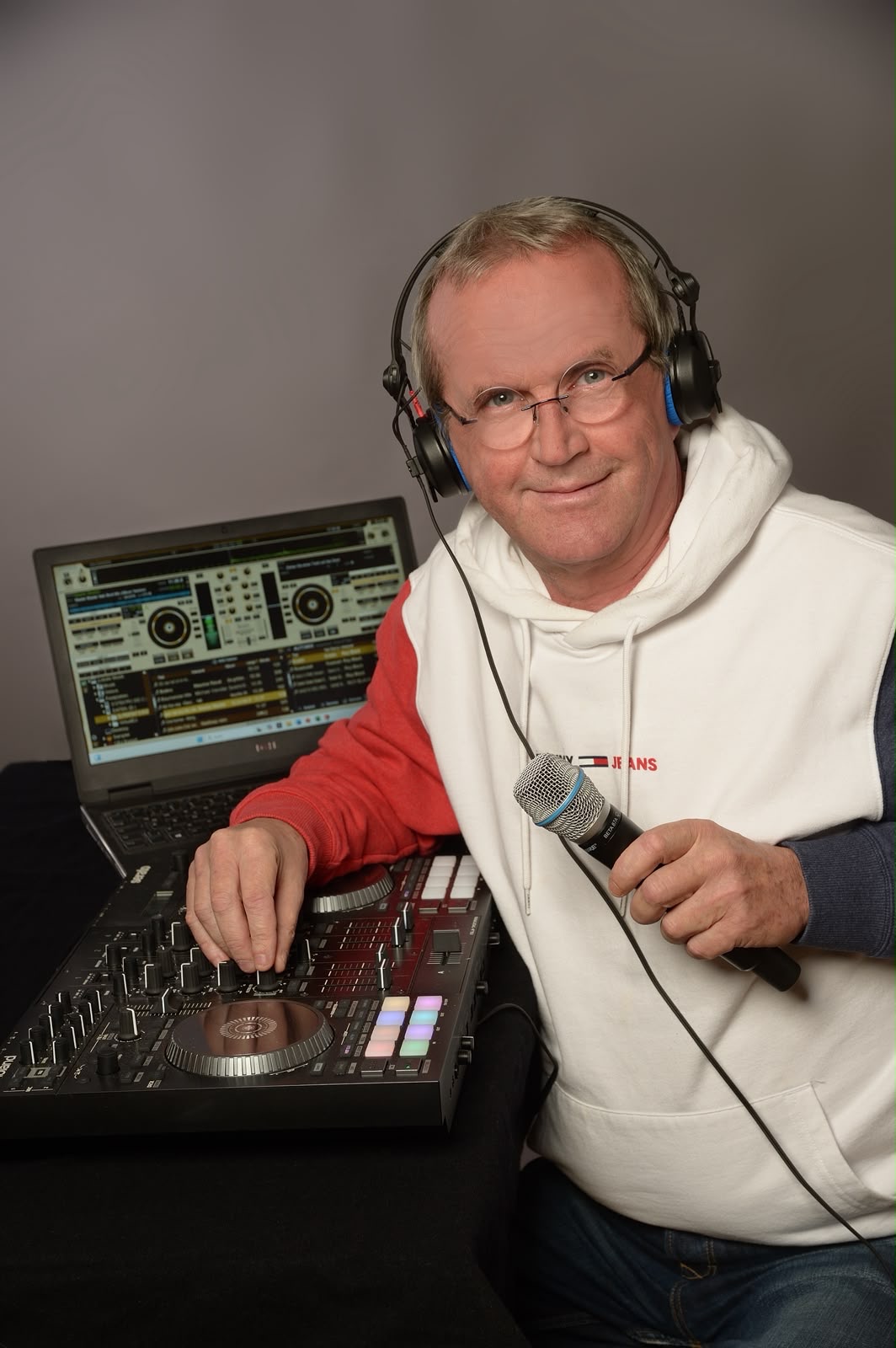 Christian mit Kopfhörer und Mikrofon am DJ-Controller